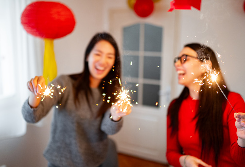 Two young woman holding sparklers and celebrating Chinese New Year