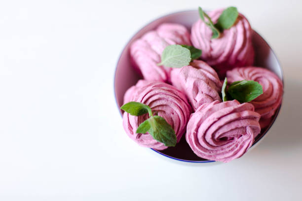 istock Pink marshmallows with mint leaves on white wooden table. Top view on sweets. 1951056167