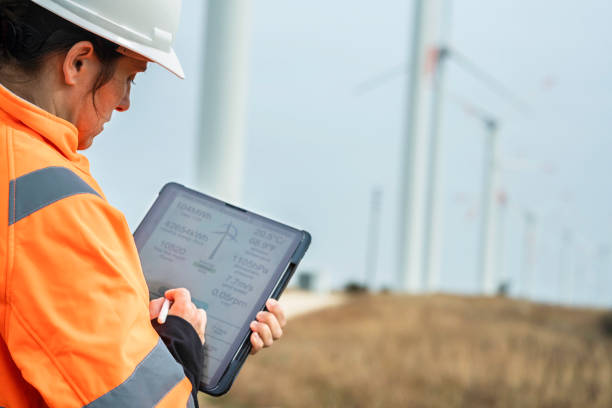 istock Female engineer works in wind farm with mobile app. copy space 1951089461