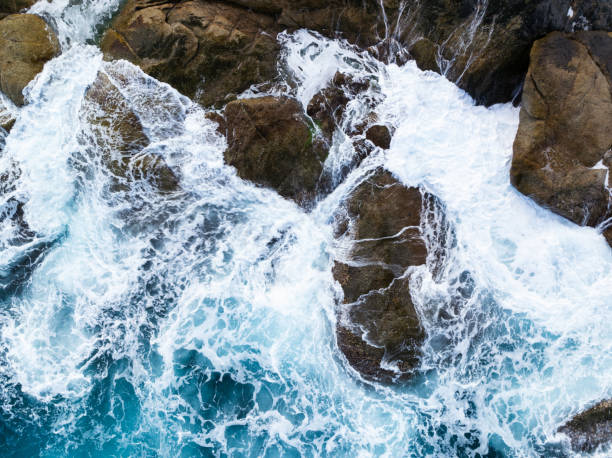 istock Waves crashing on seashore rocks,Top view sea surface waves background 1951096492