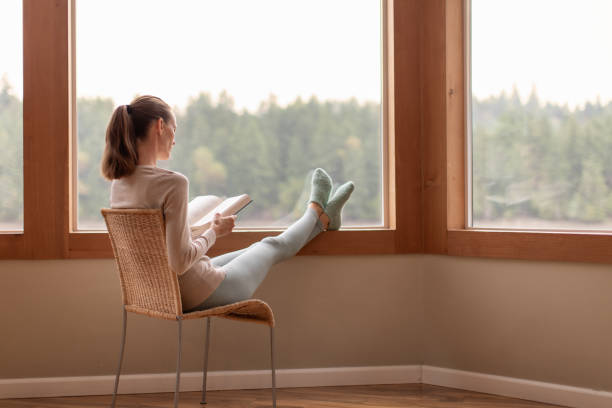 istock Woman reading a book at home. 1951135452
