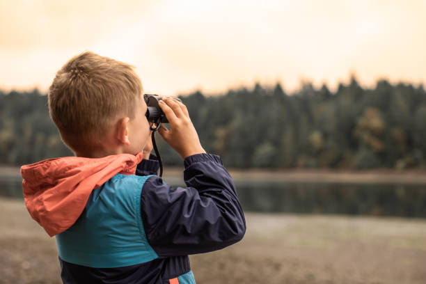 istock Little boy with binoculars exploring nature wildlife 1951156998