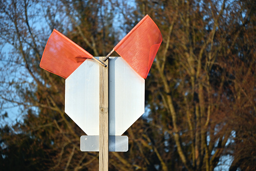 Back side of stop sign with orange flags.