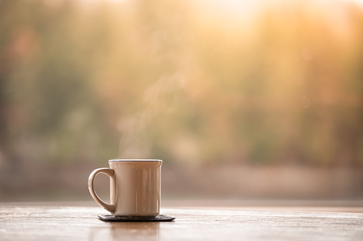 Coffee on the table with a sunrise natural background.