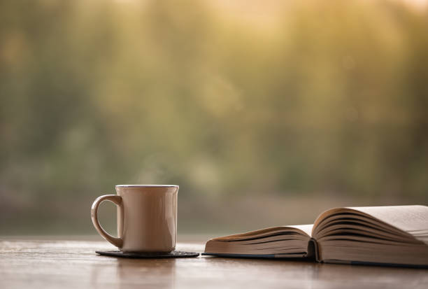 istock Book, coffee or tea on a table. Relax and read at home concept . 1951184637