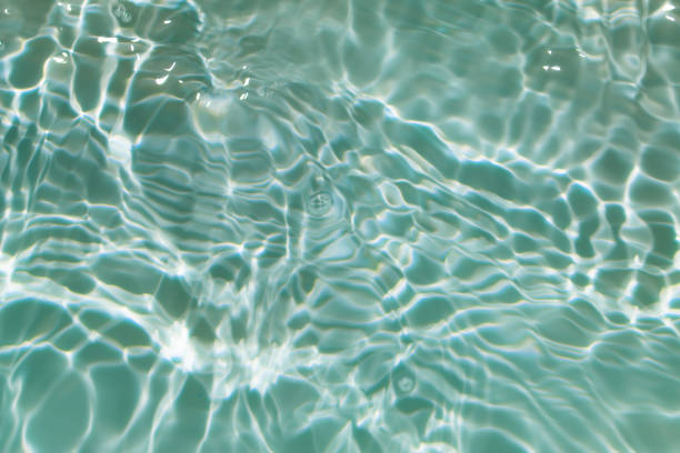 istock Bluewater waves on the surface ripples blurred. Defocus blurred transparent blue colored clear calm water surface texture with splash and bubbles. Water waves with shining pattern texture background. 1951199511