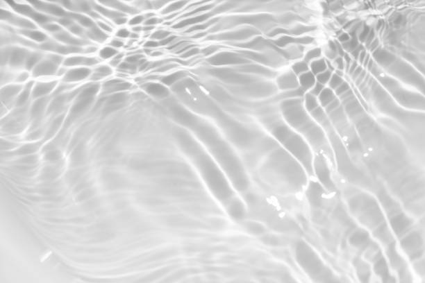 istock White water with ripples on the surface. Defocus blurred transparent white colored clear calm water surface texture with splashes and bubbles. Water waves with shining pattern texture background. 1951200032