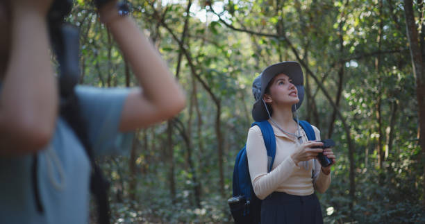 istock Two Young asian backpacker women walking in trail with digital camera in forest 1951306464