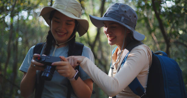 istock Young asian backpacker women use digital camera in forest in Autumn 1951307495