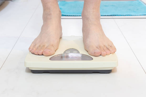 istock A person weighs himself after taking a bath 1951384432
