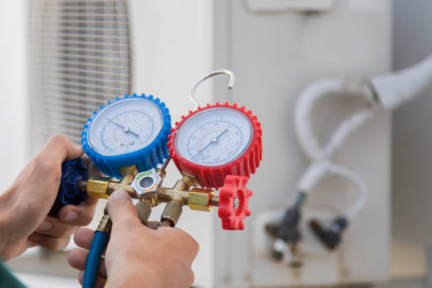 istock Air conditioning, HVAC service technician using gauges to check refrigerant and add refrigerant. 1951384561