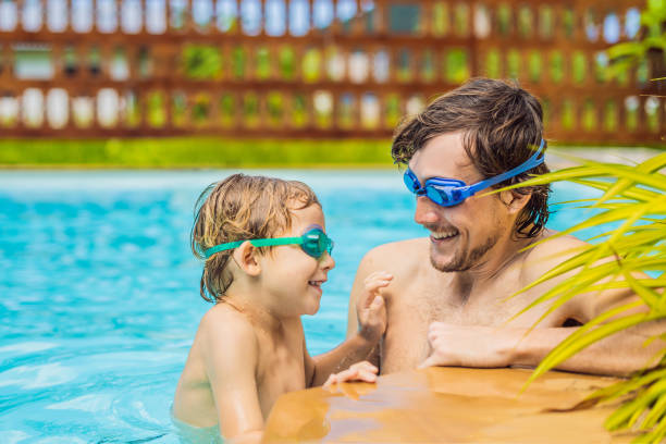 istock Dad and son in swimming Goggles have fun in the pool 1951384653