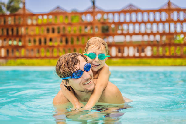 istock Dad and son in swimming Goggles have fun in the pool 1951384656