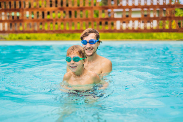 istock Dad and son in swimming Goggles have fun in the pool 1951384662