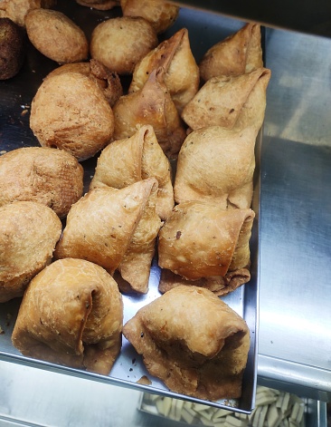 Samosa in local language. It is a fried or baked pastry with a savoury filling, such as spiced potatoes, onions, peas etc. It is triangular cone shaped.