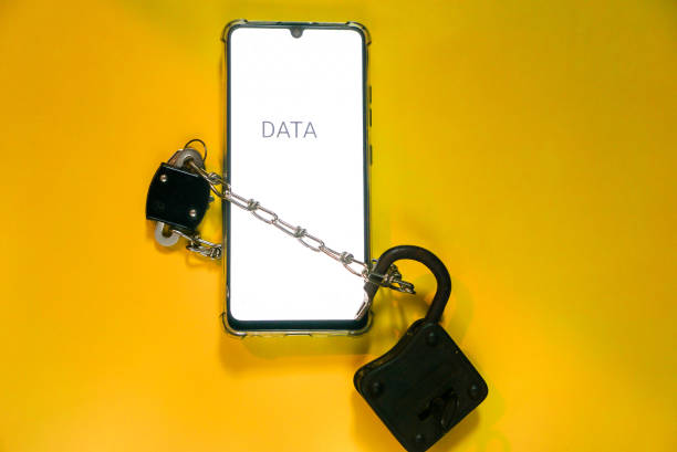 istock Phone security concept. Smartphone locked with chain and padlock on yellow background. Mobile security and data privacy. 1951442099