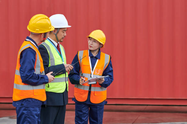 istock Three Asian Coworker Discussing at Red Cargo Container Backgrounds 1951451611