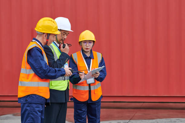 istock Three Asian Coworker Discussing at Red Cargo Container Backgrounds 1951452624