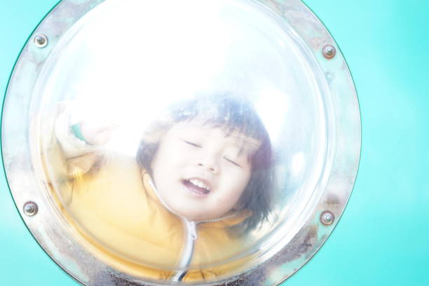 Child looking through a circular window in the park