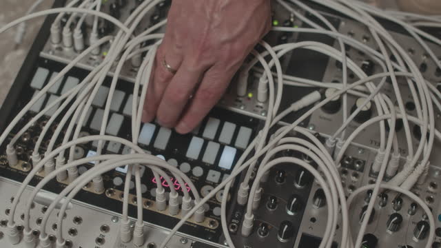 Hand Pressing Buttons on Modular Synthesizer