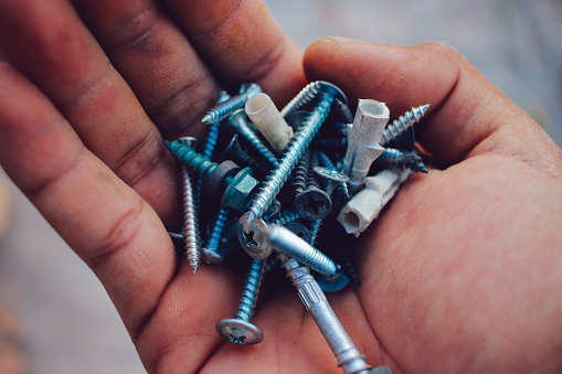 Different metal bolts and nuts on white background, top view