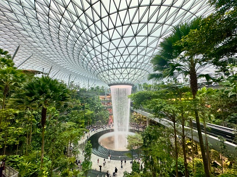 Singapore - January 7, 2024: Modern Architecture of the Singapore The Jewel at Changi Airport with Tourists and Visitors at the Rain Vortex waterfall. The Singapore Jewel Rain Vortex is the largest indoor waterfall in the world located inside the Jewel Changi Airport in Singapore, Southeast Asia.