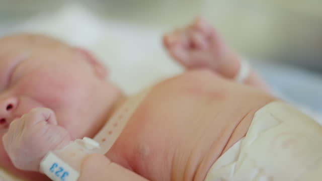 MS Newborn Innocence: Tiny Hands of a Newborn Resting in Hospital Crib at Maternity Ward