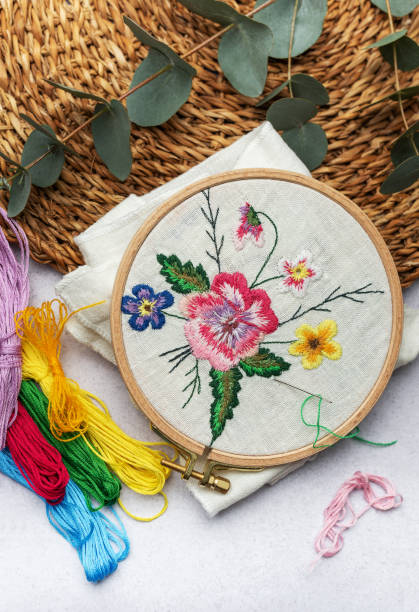 istock The process of hand embroidering a napkin with colored threads on white fabric. 1951634070
