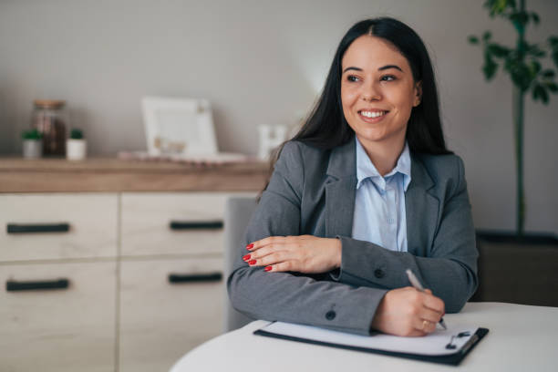 istock Thoughtful business woman in modern home office making notes on clipboard 1951652522