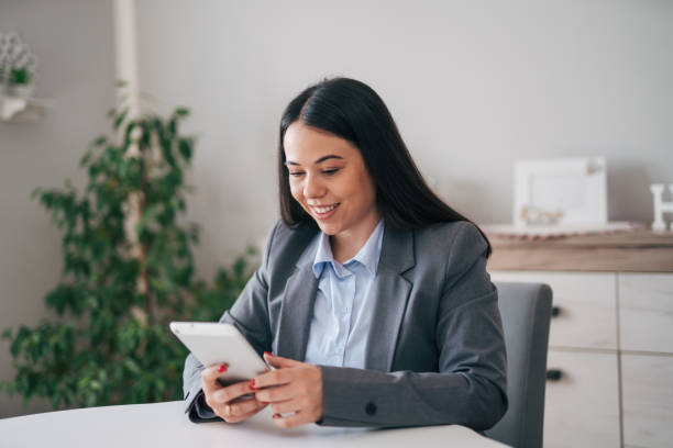 istock Smiling young businesswoman relaxing at home and using tablet 1951658586