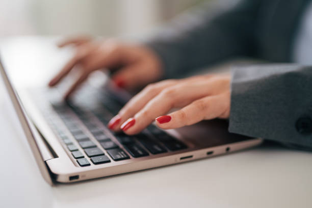 istock Close-up of woman's hands typing on laptop 1951690166