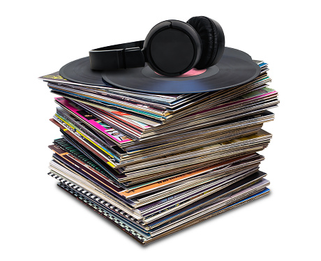 pile of old vinyl discs and headphones isolated on white background