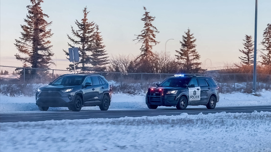 Calgary, Alberta, Canada. Jan 21, 2024. A driver stopped by the police on the road during winter.
