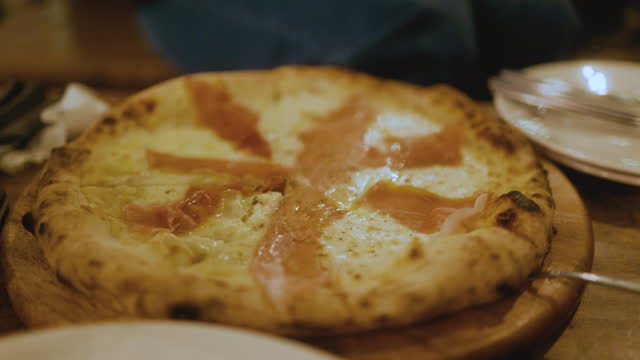Close up - Parma ham cheese pizza served on the table. Looks very delicious. Dinner night. 4k.