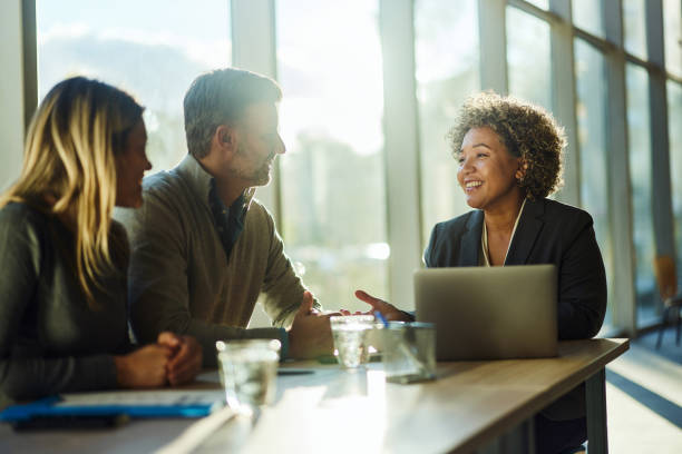 istock Happy insurance agent talking to her customers in the office. 1951815938