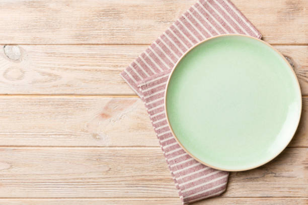 istock Top view on colored background empty round green plate on tablecloth for food. Empty dish on napkin with space for your design 1951816470