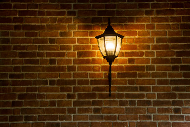 istock Illuminated retro vintage street lamp on brick wall 1951816482