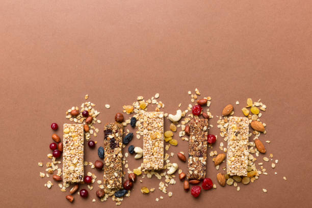 various granola bars on table background. cereal granola bars. superfood breakfast bars with oats, nuts and berries, close up. superfood concept - protein bar cereal oat cranberry fotografías e imágenes de stock