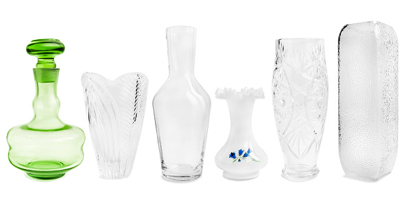 Collection of different empty glass vases and decanters isolated over white