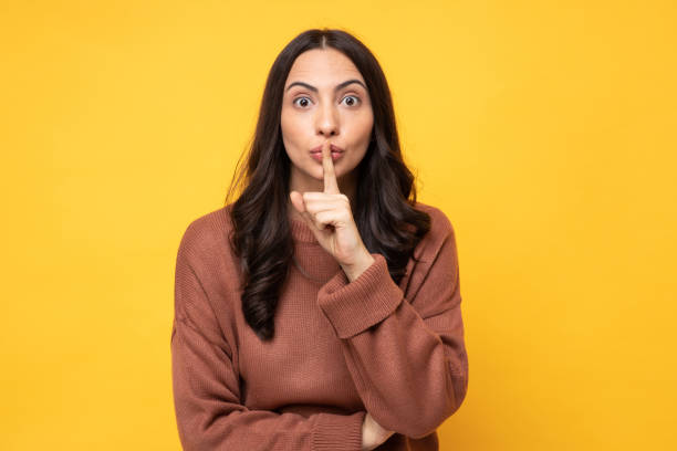 Photo of young women in winter wear standing on yellow background stock photo Photo of young women in winter wear standing on yellow background whisperer pictures stock pictures, royalty-free photos & images