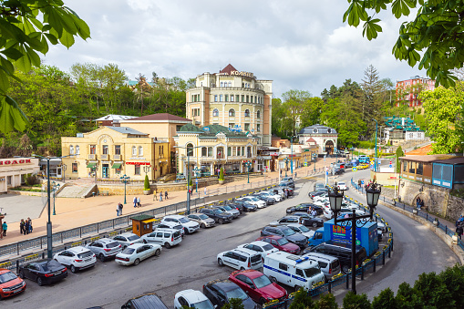 Kislovodsk, Russia - May 9, 2023: Vokzalnaya street view with. Ordinary people walk the street near parking lot