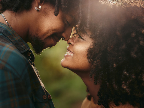Profile view of loving African American couple being close to each other in nature.