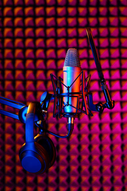 istock Professional studio microphone against acoustic foam panel background in neon light 1951853760