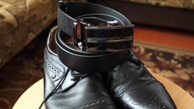 Black leather shoes and a black leather belt. Quality stylish clothes.