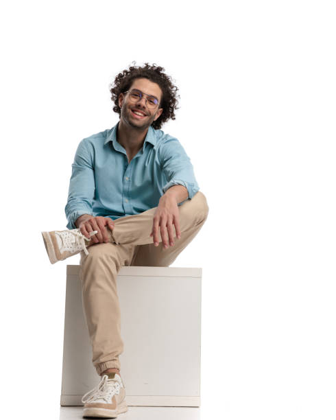 istock casual man sitting on a box with legs crossed 1951905824