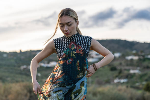 Girl dancing in the mountains at sunset holding some yellow flowers