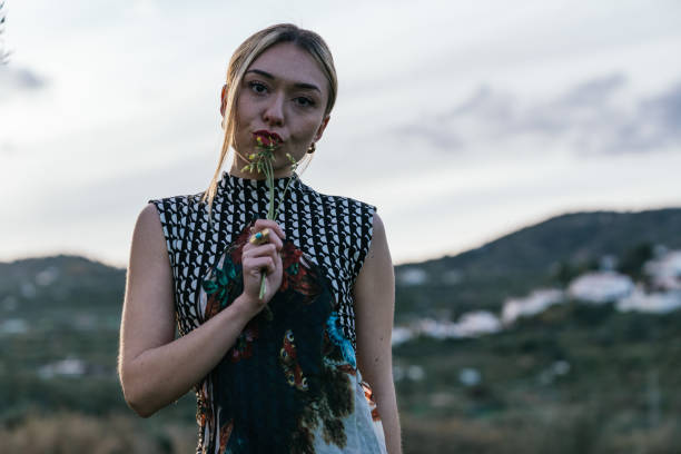 Girl dancing in the mountains at sunset holding some yellow flowers