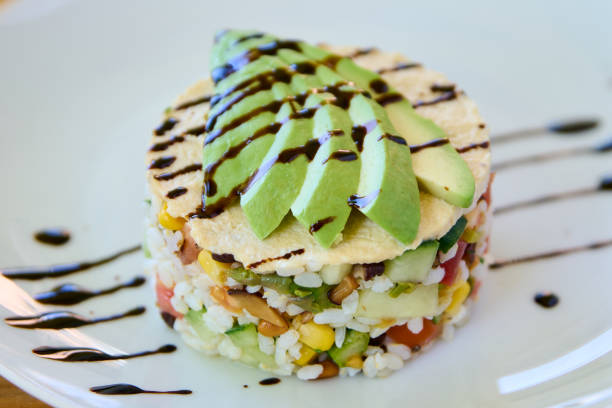 istock Avocado tartare with rice and vegetables on a white plate. 1951957626
