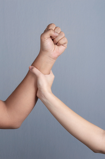 Woman using hand to stop man's punch from attack isolated on gray background.stop violence against women concept