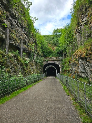 A scenic tunnel framed by imposing rock formations and trees